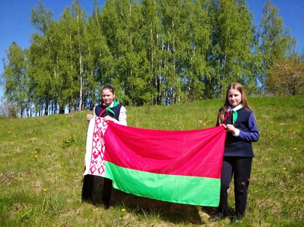 Молодые люди делают фото с государственным флагом. Узнали зачем